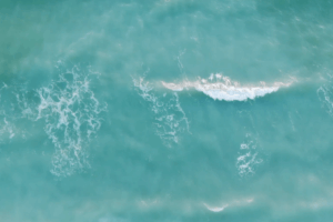 Gentle turquoise waves rolling across the sea Soft turquoise sea waves viewed from above