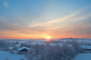 Sunrise illuminating snow-covered countryside Snowy winter morning with colorful sunrise sky